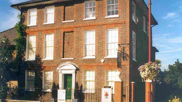 A view of a red brick building with a green door