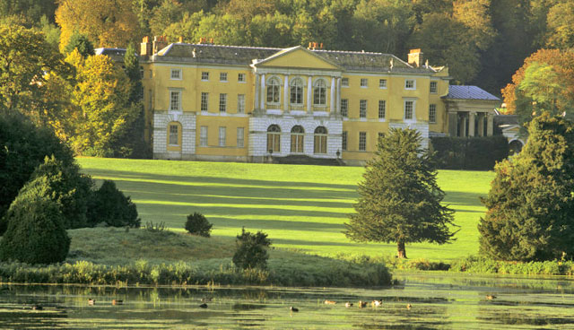 View of the north front of the house at West Wycombe Park, Buckinghamshire, with a sweep of grass stretching to the shores of a lake 