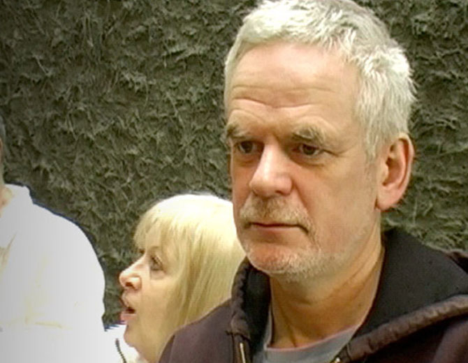 A photograph showing a man's face against a green background.