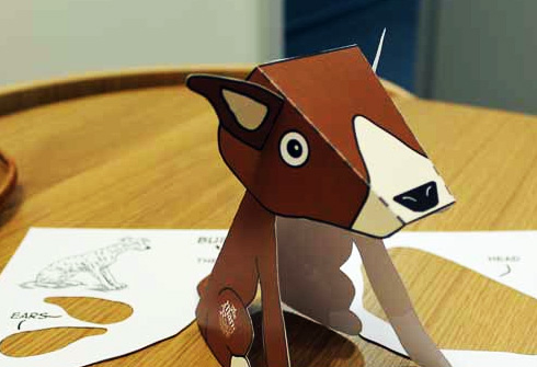 A photpgraph showing a dog made out of card