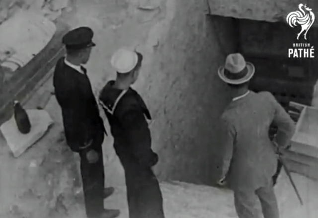 Three men standing in front of dark imb